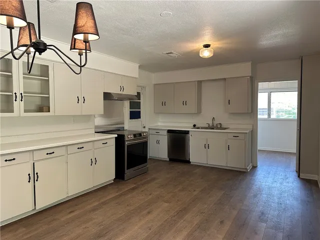 a kitchen with stainless steel appliances granite countertop a sink and dishwasher with wooden floor