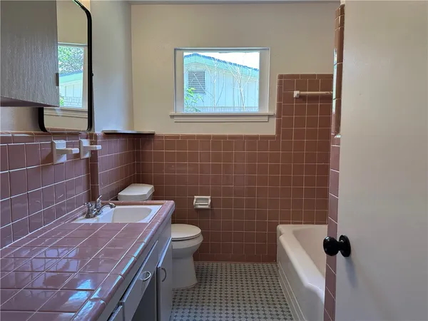 a bathroom with a sink a toilet and a mirror