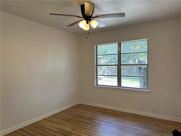 wooden floor in an empty room with a window