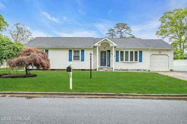 a front view of a house with a garden and plants