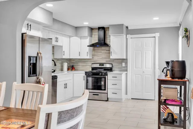 a kitchen with white cabinets and stainless steel appliances