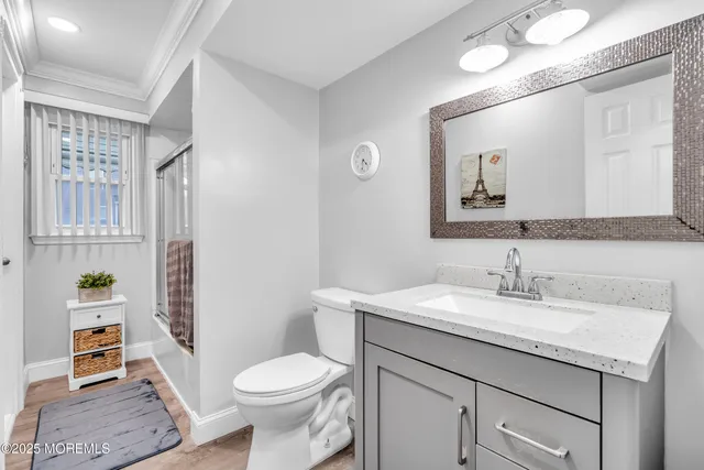 a bathroom with a granite countertop toilet sink and mirror