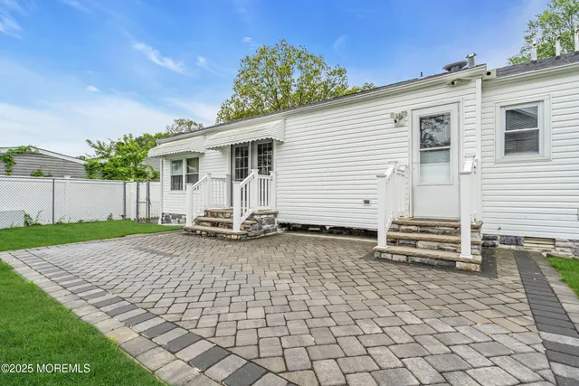 a view of a house with backyard and wooden fence