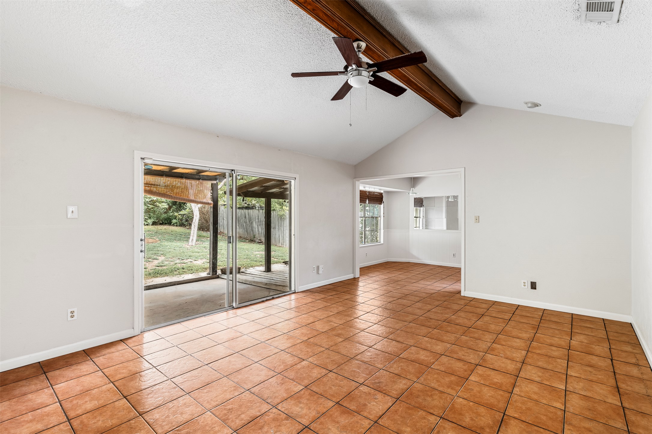 7506 Glenhill Road Austin, TX 78752 - Photo 3 of 24 A well-lit living space features vaulted ceilings, tile flooring, and seamless access to the outdoors.