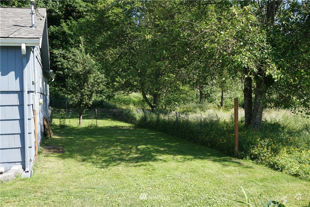 1507 South Machias Road Snohomish, WA 98290 - Photo 3 of 22 a backyard of a house with plants and large trees