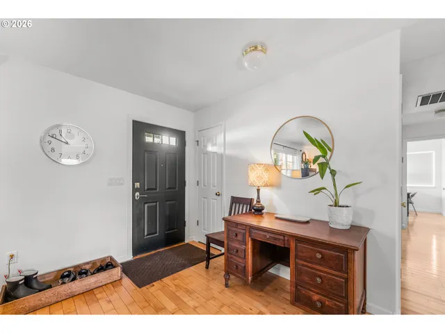 a living room with furniture a rug and wall painting