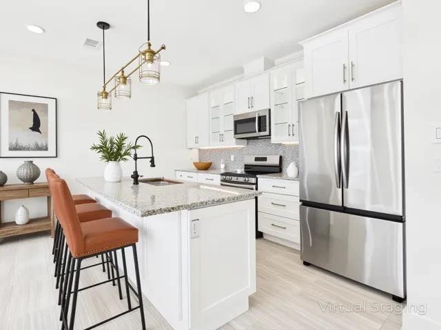 511 Richardson Street Athens, TX 75751 - Photo 5 of 40 Kitchen featuring stainless steel appliances, light stone countertops, pendant lighting, white cabinets, and recessed lighting