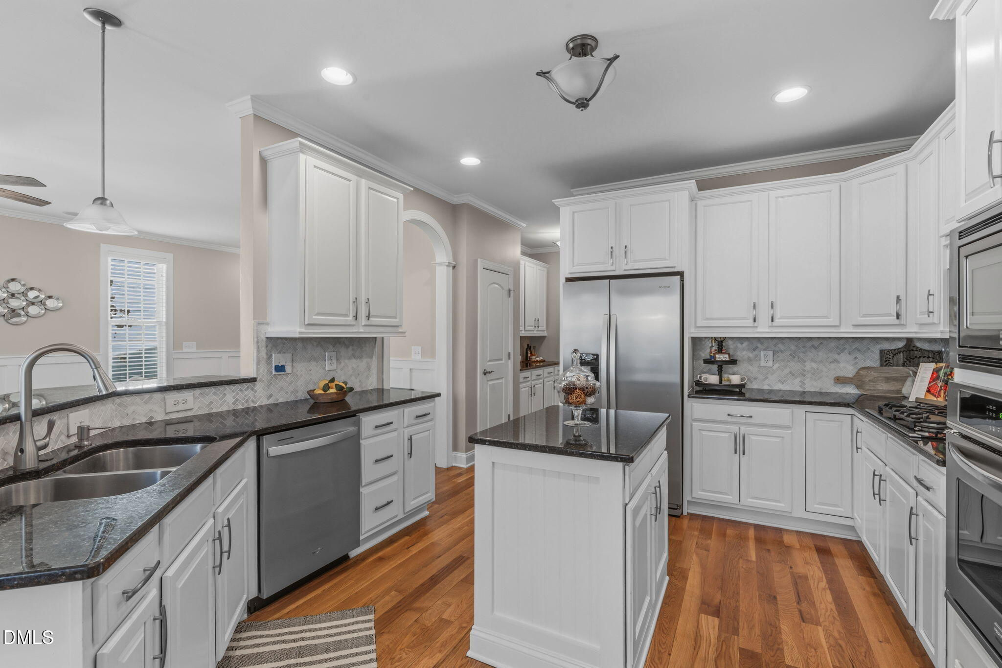 7320 Bedford Ridge Drive Apex, NC 27539 - Photo 20 of 64 a kitchen with kitchen island white cabinets appliances and a sink