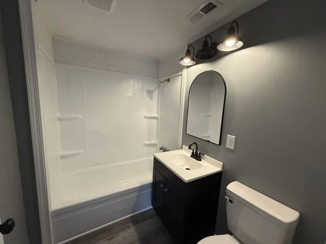 a bathroom with a toilet sink and mirror