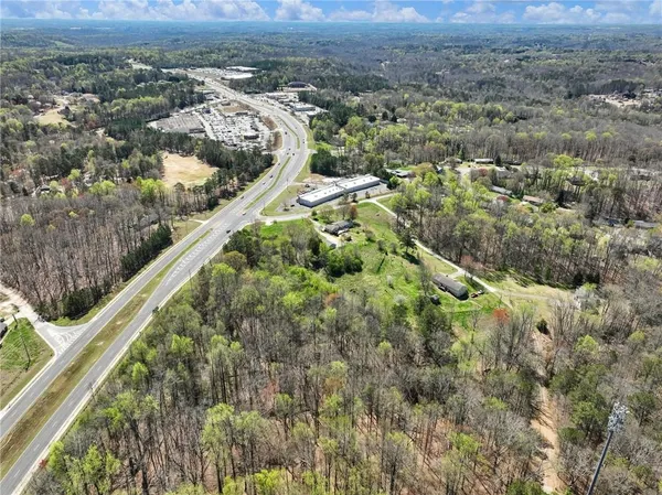 an aerial view of residential houses with outdoor space and trees