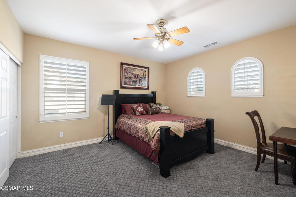 5019 Corral Street Simi Valley, CA 93063 - Photo 25 of 50 a spacious bedroom with a bed a table and chair