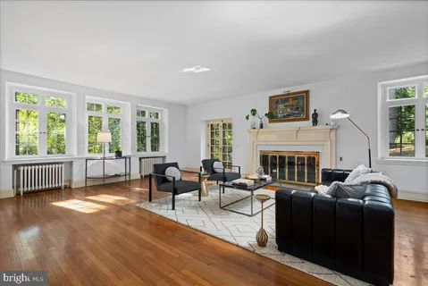 a living room with fireplace furniture and a large window