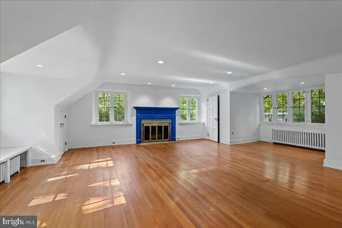 an empty room with windows and fireplace
