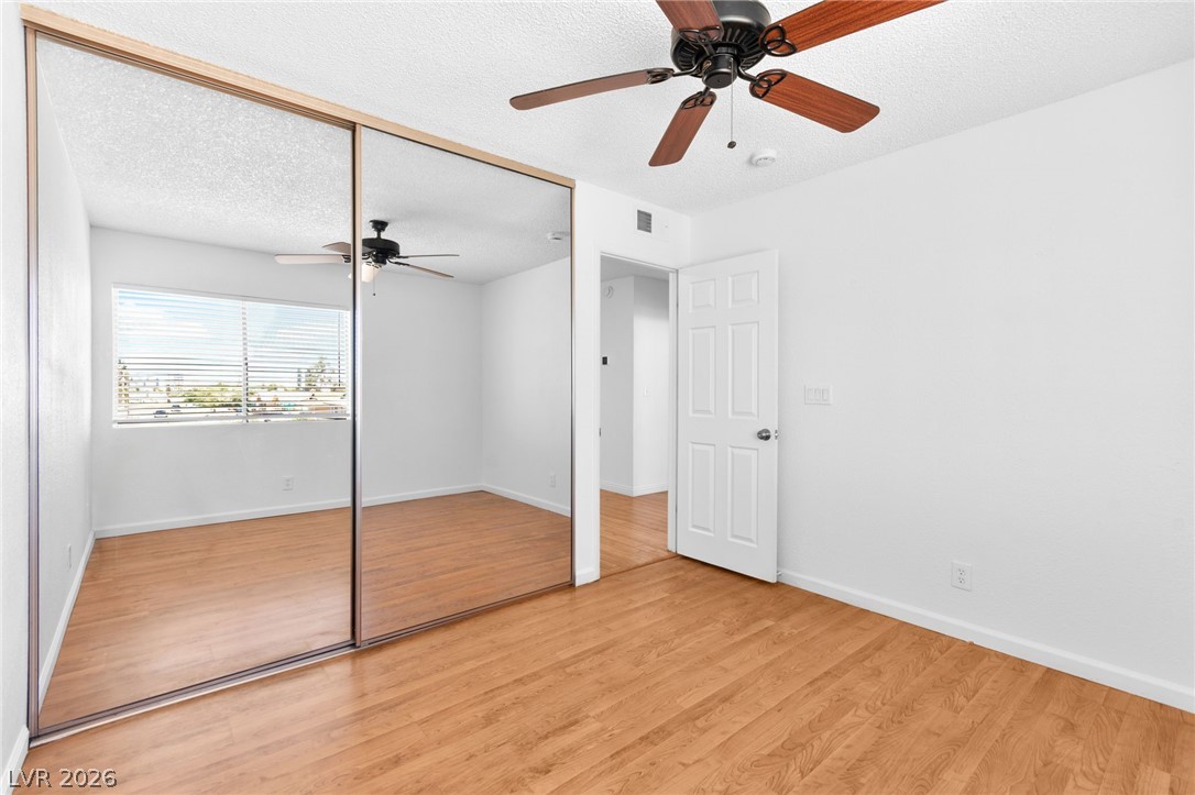 4430 Cranbrook Way Las Vegas, NV 89103 - Photo 46 of 50 Well-lit room with wood flooring, ceiling fan, and mirrored closet doors.