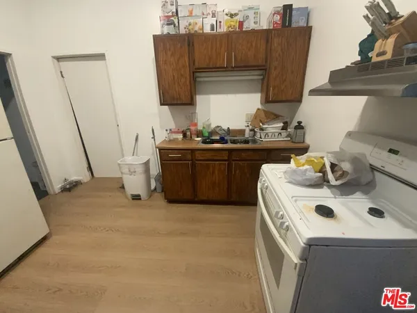 a kitchen with a sink and a stove with wooden floor