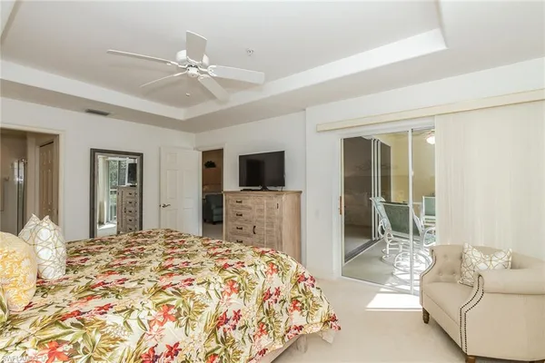 a spacious bedroom with a bed and a flat screen tv