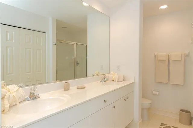 a bathroom with a double vanity sink toilet and a mirror