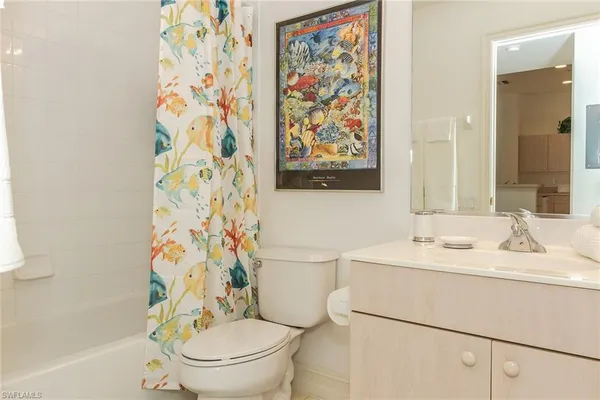 a bathroom with a sink a toilet and a shower curtain