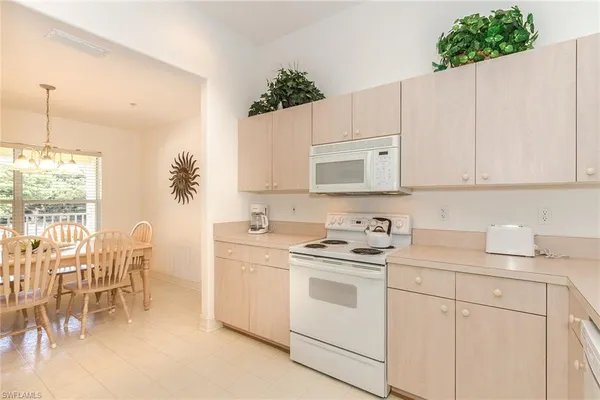 a kitchen with a white cabinets and chairs
