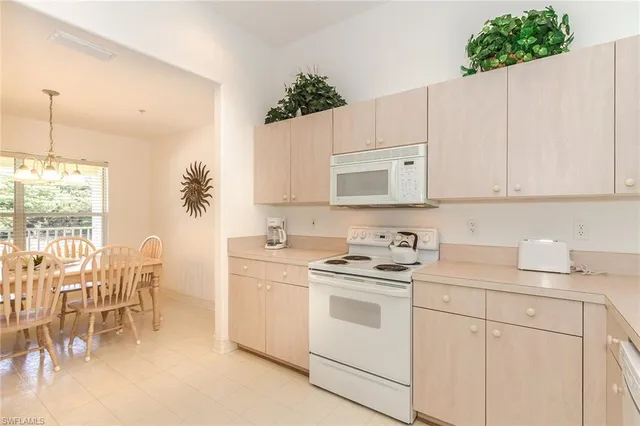 a kitchen with a white cabinets and chairs
