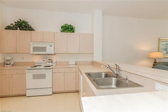 a kitchen with a sink stove and white cabinets