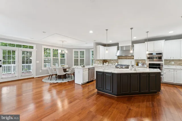 a view of a dining room with furniture a chandelier and wooden floor