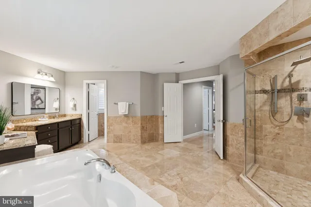 a large en suite bathroom with a granite countertop sink mirror and shower