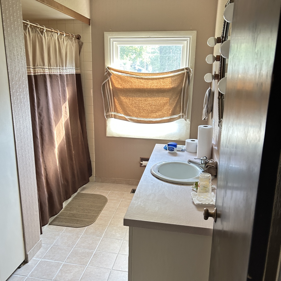 1314 174th Street East Hazel Crest, IL 60429 - Photo 3 of 4 a bathroom with a sink a mirror and a window