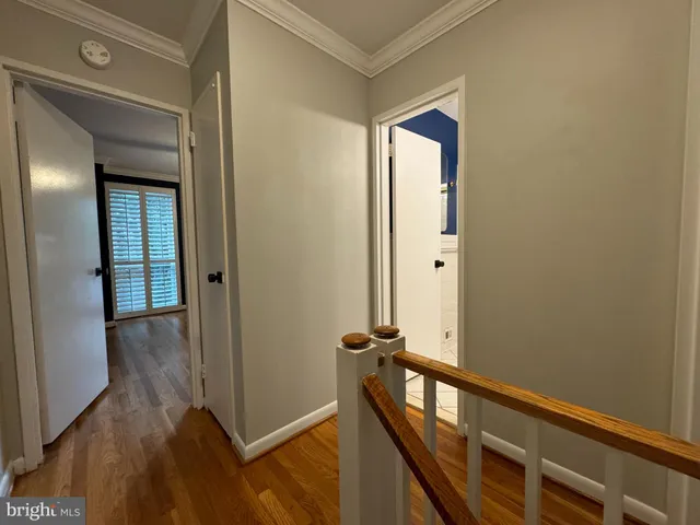 a view of a hallway with wooden floor and staircase