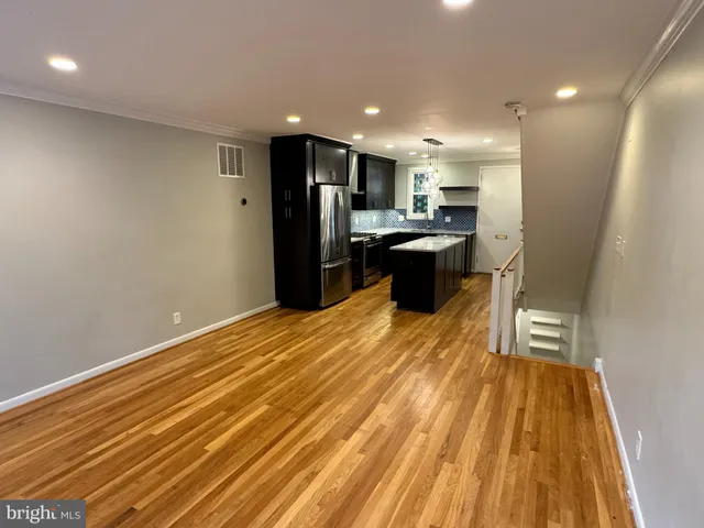 a kitchen with stainless steel appliances kitchen island granite countertop a refrigerator and a sink