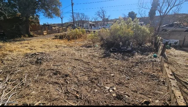 a view of a yard with wooden fence