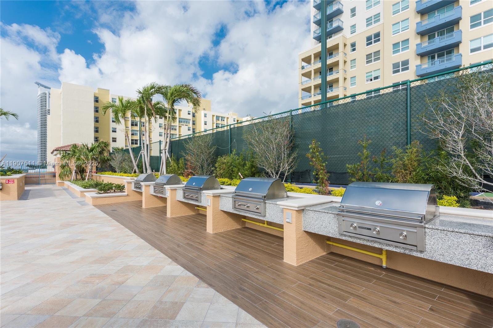 90 Alton Road, Unit 2911 Miami Beach, FL 33139 - Photo 34 of 39 a view of a patio with couches and table and chairs with wooden fence