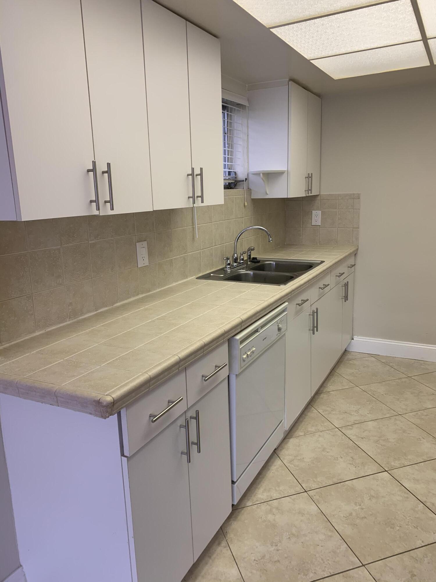 2735 Northeast 28th Court Lighthouse Point, FL 33064 - Photo 18 of 28 a kitchen with granite countertop a sink a stove and cabinets