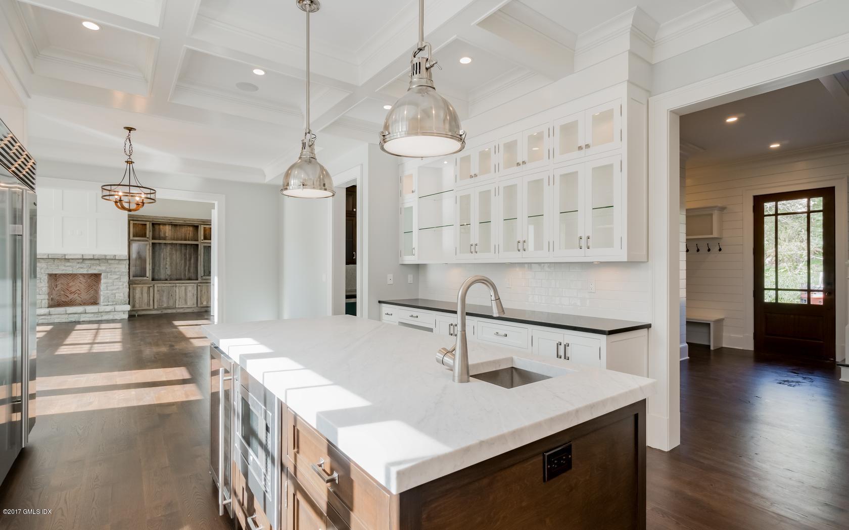 171 Cognewaugh Road Cos Cob, CT 06807 - Photo 13 of 31 a kitchen with a sink a center island a wooden floor and a chandelier