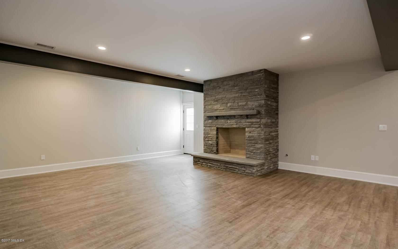 171 Cognewaugh Road Cos Cob, CT 06807 - Photo 27 of 31 a view of an empty room with wooden floor and a fireplace