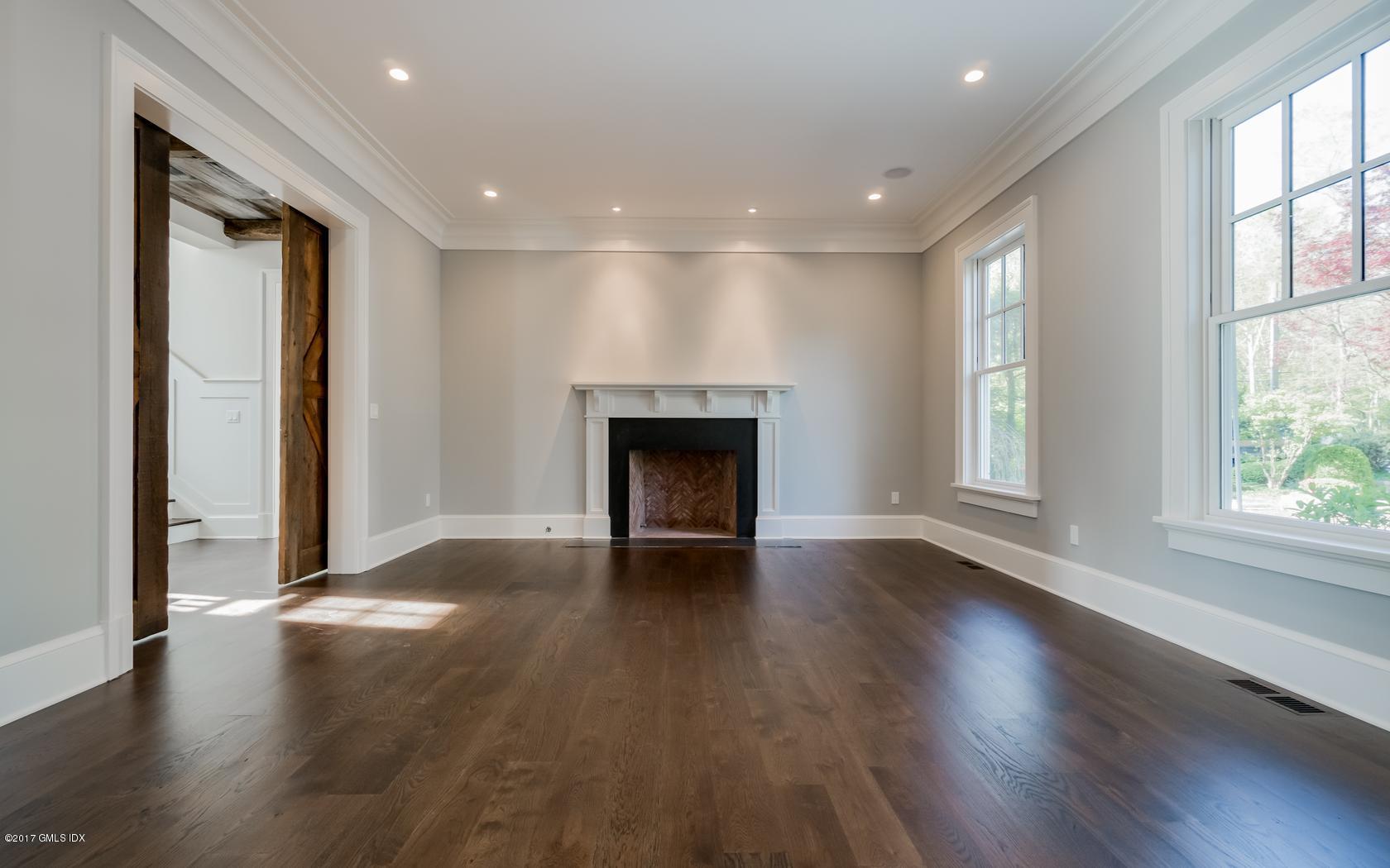 171 Cognewaugh Road Cos Cob, CT 06807 - Photo 6 of 31 an empty room with wooden floor fireplace and windows