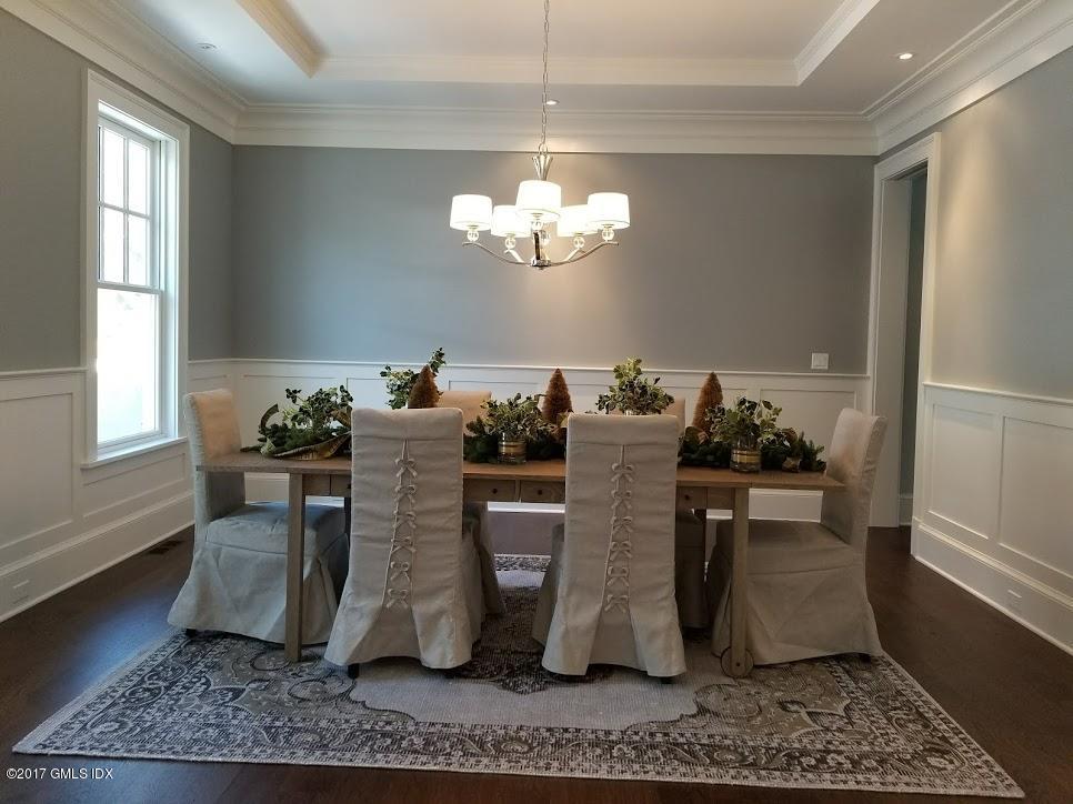 171 Cognewaugh Road Cos Cob, CT 06807 - Photo 7 of 31 a dining room with wooden floor and a chandelier