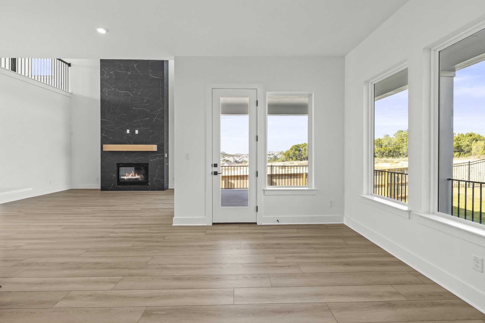 783 Iron Willow Loop Dripping Springs, TX 78620 - Photo 11 of 28 an empty room with wooden floor and a window