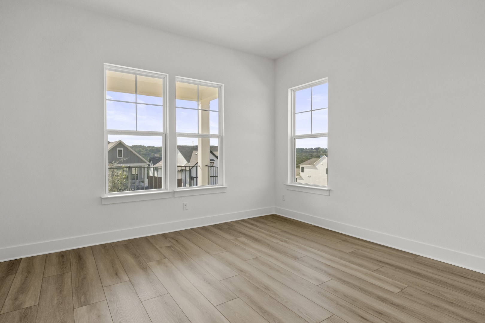 783 Iron Willow Loop Dripping Springs, TX 78620 - Photo 27 of 28 an empty room with wooden floor and windows