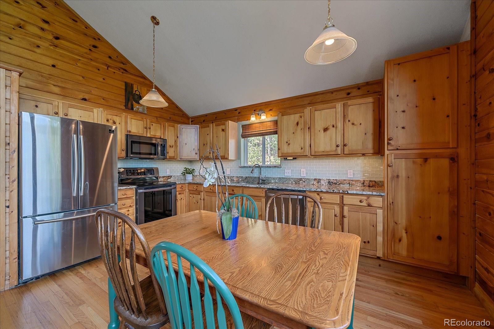 153 Wise Road Bailey, CO 80421 - Photo 11 of 38 a kitchen with stainless steel appliances granite countertop a refrigerator a stove top oven a sink dishwasher and wooden cabinets