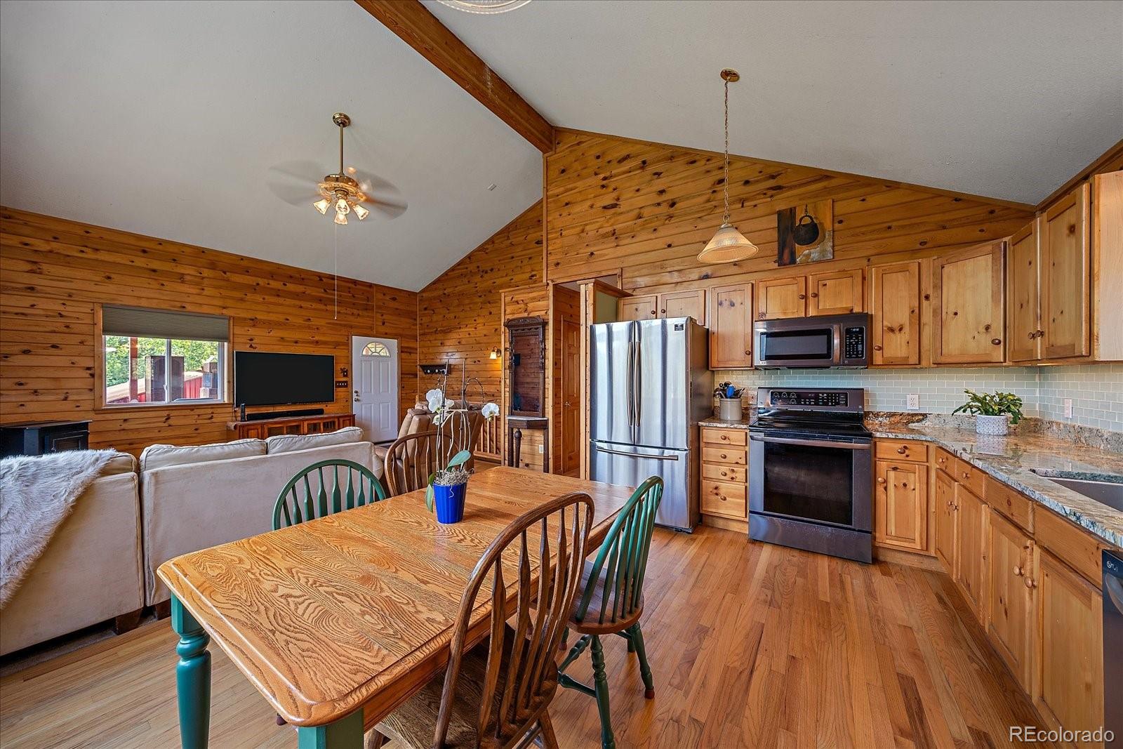 153 Wise Road Bailey, CO 80421 - Photo 12 of 38 a kitchen with stainless steel appliances kitchen island granite countertop a table chairs and a refrigerator