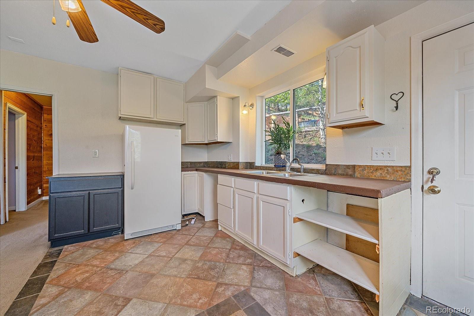 153 Wise Road Bailey, CO 80421 - Photo 21 of 38 a kitchen with a refrigerator and white cabinets