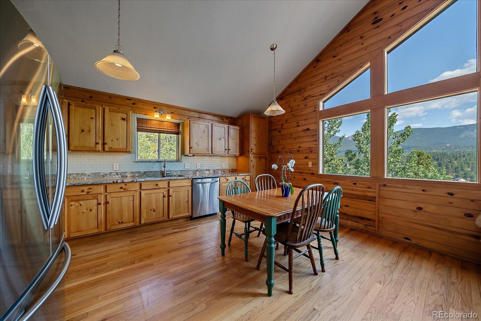 153 Wise Road Bailey, CO 80421 - Photo 10 of 38 a kitchen with kitchen island granite countertop wooden floors and stainless steel appliances