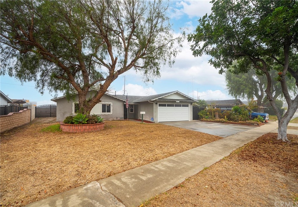 a front view of a house with yard and trees