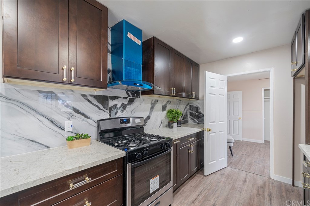 10941 Mac Street Anaheim, CA 92804 - Photo 13 of 41 a kitchen with stainless steel appliances granite countertop a stove and a wooden cabinets