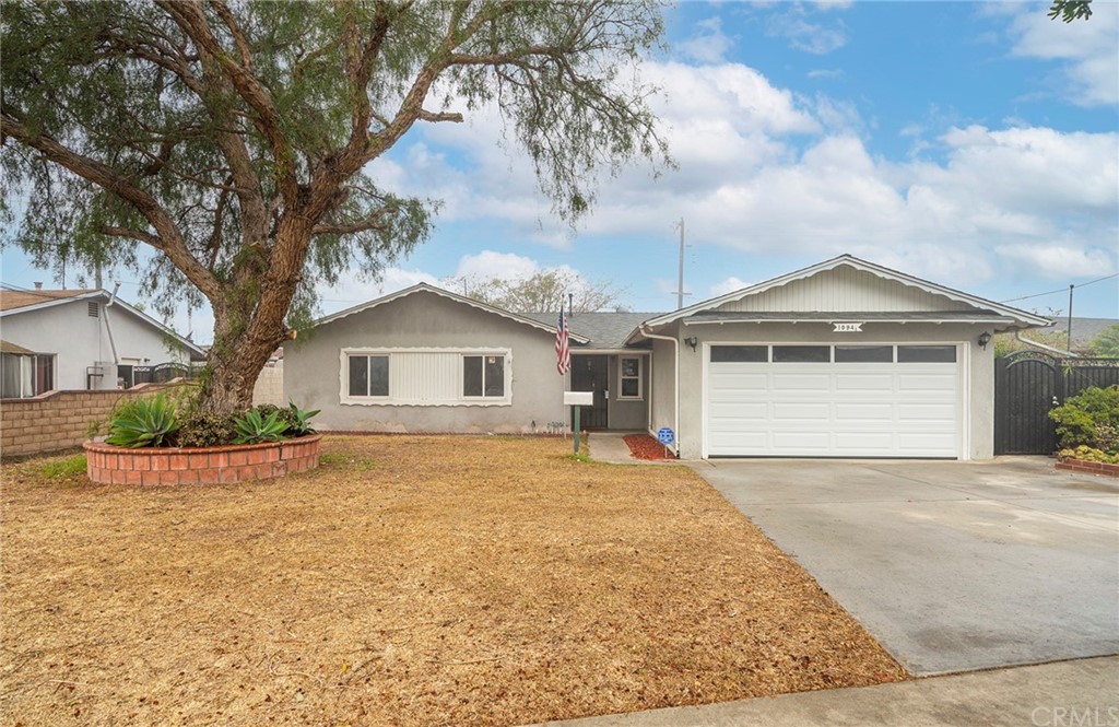 10941 Mac Street Anaheim, CA 92804 - Photo 3 of 41 a front view of a house with a yard and garage