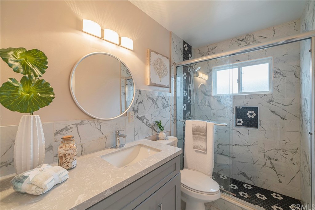 10941 Mac Street Anaheim, CA 92804 - Photo 23 of 41 a bathroom with a granite countertop toilet sink and mirror