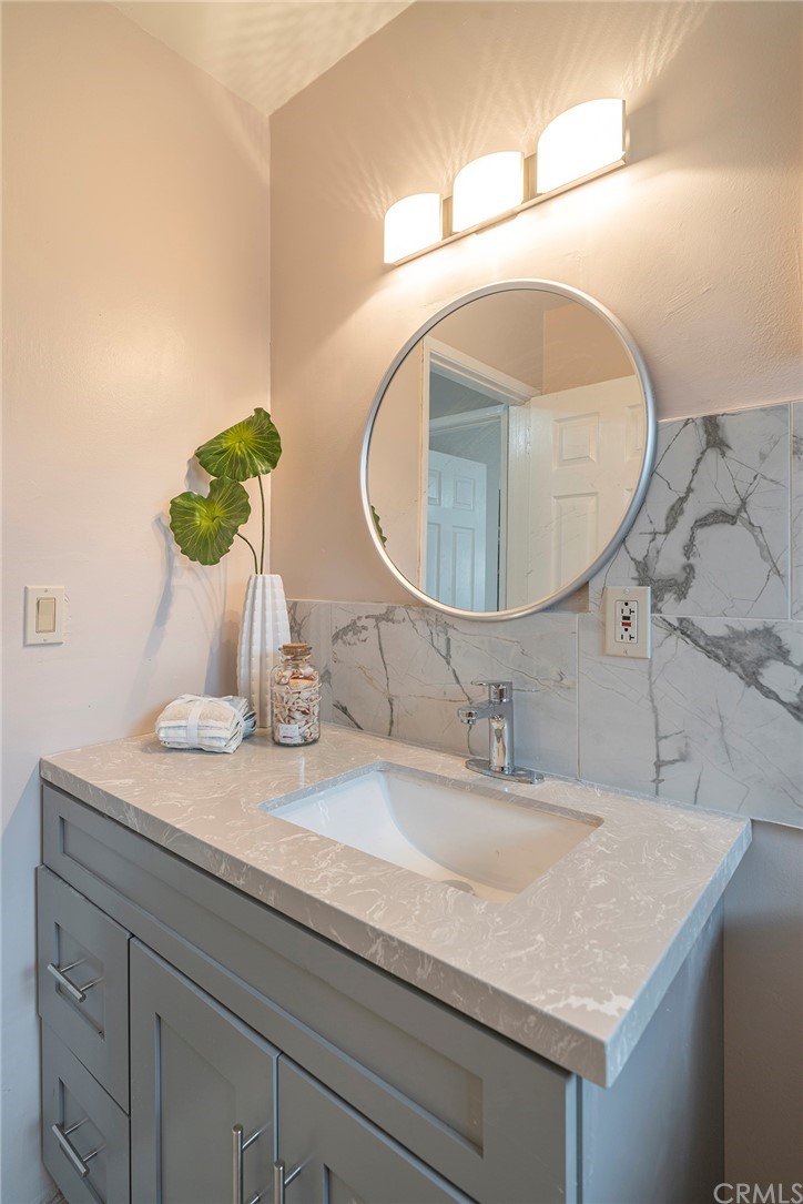 10941 Mac Street Anaheim, CA 92804 - Photo 25 of 41 a bathroom with a granite countertop sink a mirror and vanity