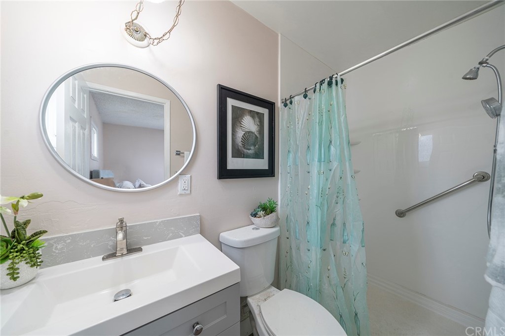 10941 Mac Street Anaheim, CA 92804 - Photo 29 of 41 a bathroom with a sink toilet a mirror and shower