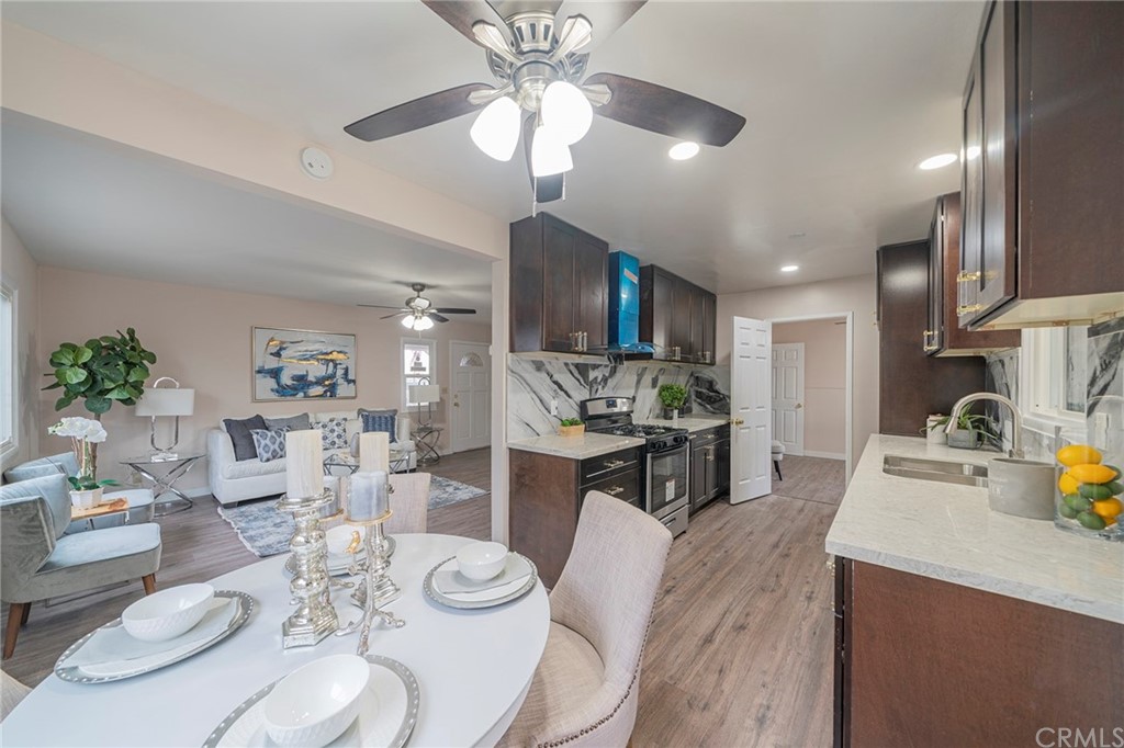 10941 Mac Street Anaheim, CA 92804 - Photo 9 of 41 a kitchen with stainless steel appliances kitchen island granite countertop a stove a sink a dining table and chairs with wooden floor